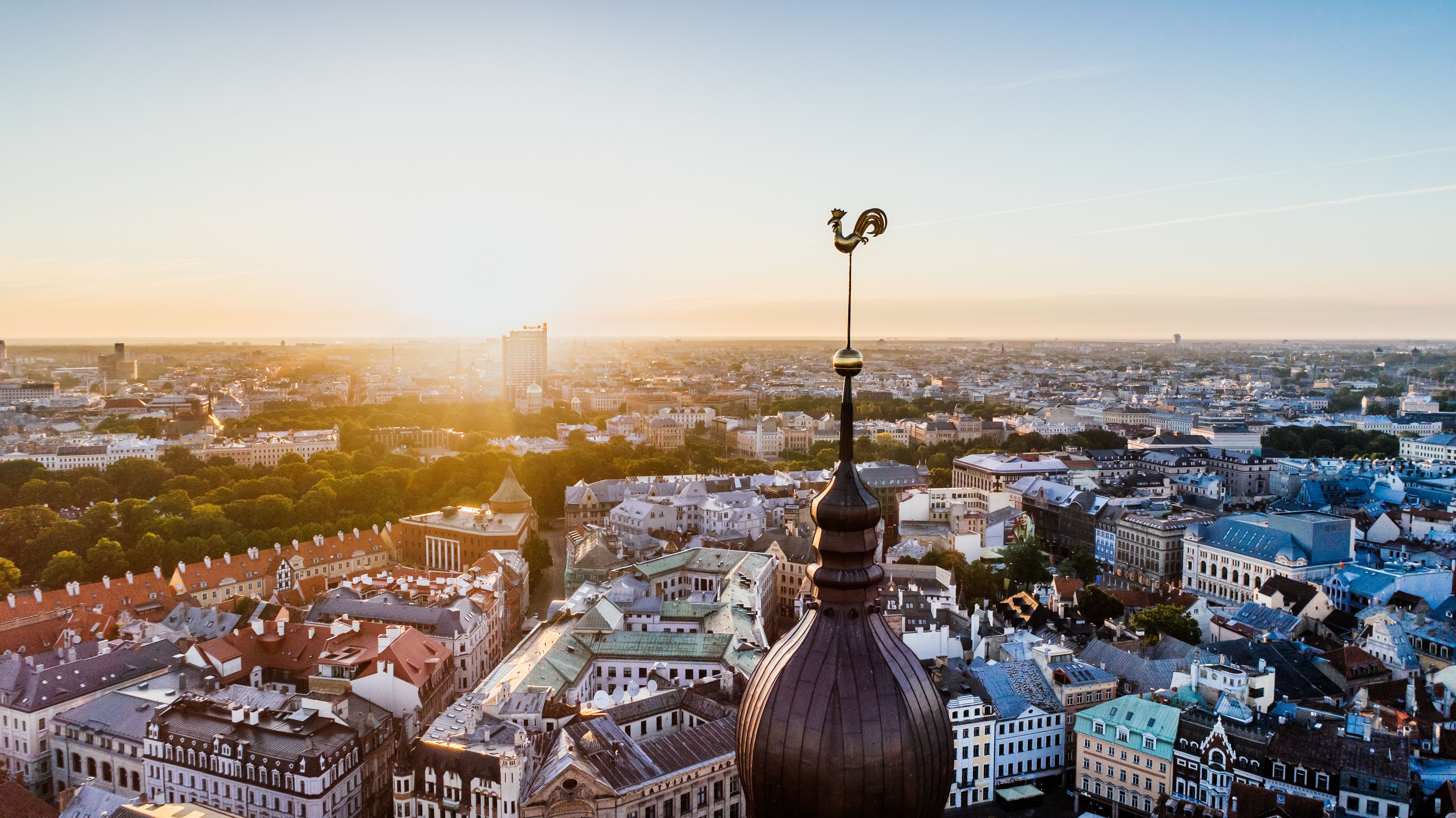 Utsikt over Riga ved soloppgang med byens tak og spir